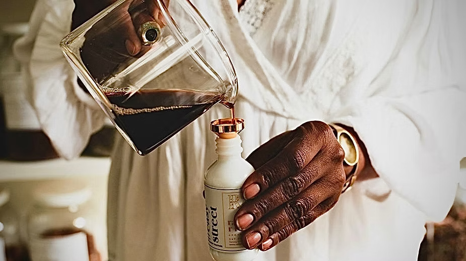 A herbal syrup pouring to bottle. 